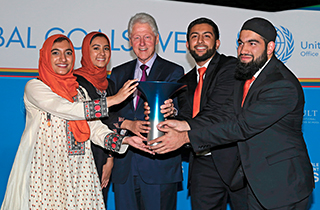 Rutgers' Hult Prize winners holding trophy with former President Clinton